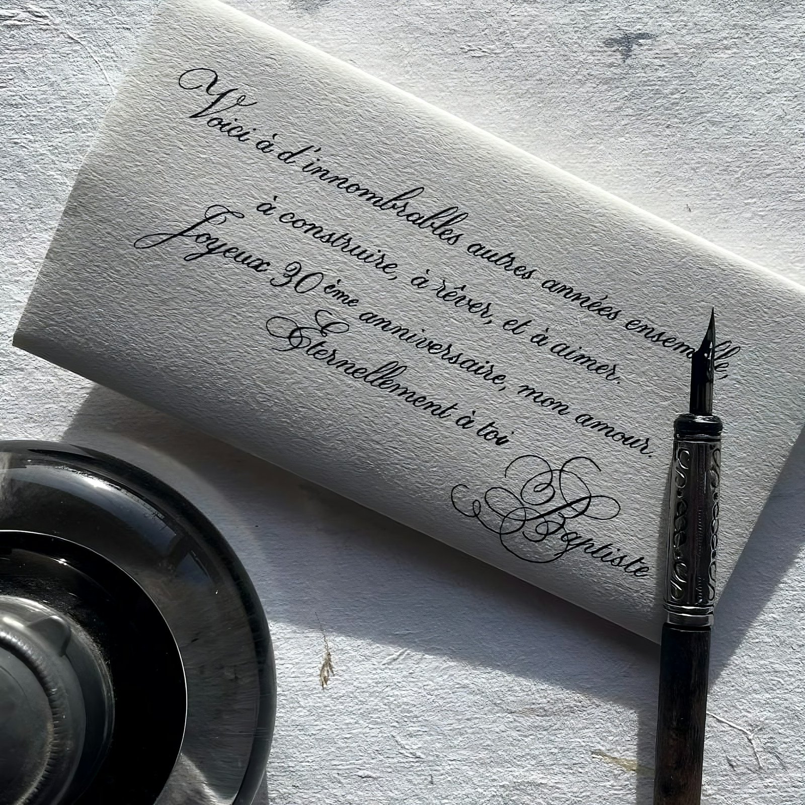 A handwritten letter with a fountain pen and inkwell