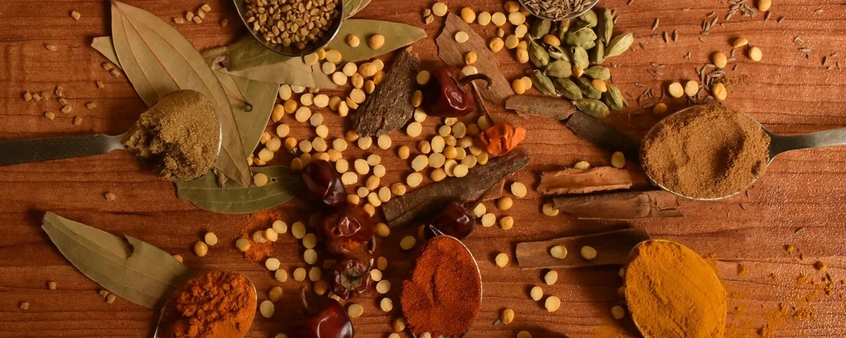 Whole and ground spices in wooden spoons